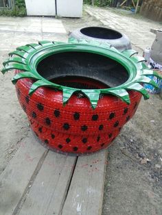 a large red and green pot sitting on top of a wooden table