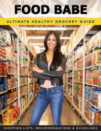 a woman standing in the aisle of a grocery store with her arms crossed and smiling