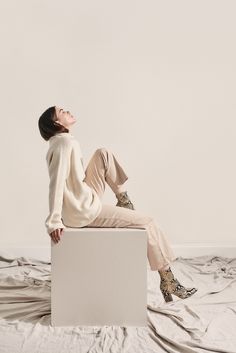 a woman sitting on top of a white box