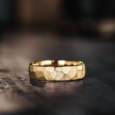 a gold wedding ring sitting on top of a table