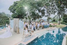 an outdoor wedding ceremony in the middle of a pool with people standing around and looking at it