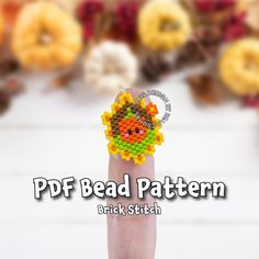 a person's hand with a bead pattern on it and donuts in the background