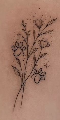 the back of a woman's shoulder with flowers and leaves tattooed on her left side