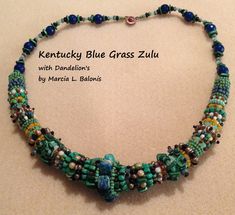 a necklace made with beads and glass beads on a white surface, next to the words kentucky blue grass zulu