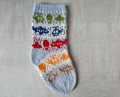 a pair of socks with colorful designs on them sitting on top of a white surface