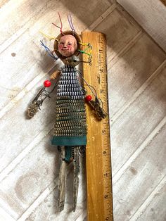 a wooden ruler with a doll on top of it