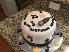 a birthday cake with musical notes and stars on it sitting on a kitchen countertop