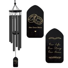 a black wind chime with two gold wedding rings and our love story written on it