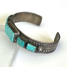 Vintage Signed - Albert Jake Navajo Kingman Turquoise Sterling Silver Cuff Markings “Sterling” “ A.Jake” Hallmark For Albert Jake, Navajo Verified Kingman Turquoise Total Weight ~ 42.1 Grams Cuff Width ~ 3/4” Cuff Length ~ 5 3/4” Cuff Gap 1 1/4”, Some Flex Large Center Turquoise Stone ~ 1/2 X 7/8” X4mm (2) Medium Turquoise Stone ~ 5/16 X 7/16” X 4mm (2) Small Turquoise Stone ~ 4/16 X 6/16” X 4mm Albert Jake Was Born In 1959 In The Zuni Pueblo South Of Gallup, New Mexico. He Learned Silversmithing From His Parents. He Specializes In Traditional Set Stones And Cluster Jewelry With Intricate Stamp Work. He Has Been Smithing Since 1987. He Also Create Gallup New Mexico, Cluster Jewelry, Hippie Bracelets, Kingman Turquoise, Sterling Silver Cuff, Silver Cuff, Turquoise Sterling Silver, Turquoise Stone, Vintage Signs