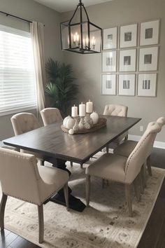 a dining room table with chairs and pictures on the wall behind it, along with an area rug