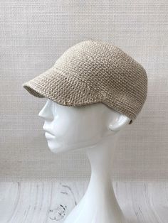 a white mannequin head wearing a beige hat