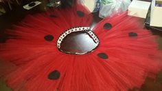 a red tutu skirt with black polka dots on it and a hole in the middle