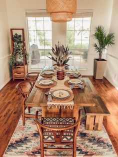 the dining room table is set with plates and place settings