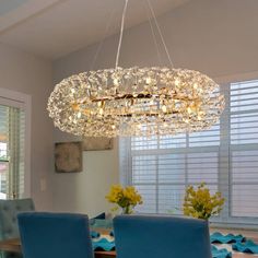 a dining room table with blue chairs and a chandelier hanging from the ceiling