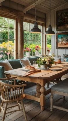 a wooden table sitting in the middle of a room with lots of windows and chairs