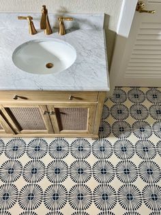 a white sink sitting next to a wooden cabinet under a faucet in a bathroom