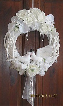 a white wreath with two birds and flowers