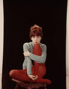 a woman sitting on top of a chair with her arms crossed