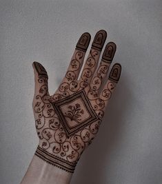 a hand with henna tattoos on it