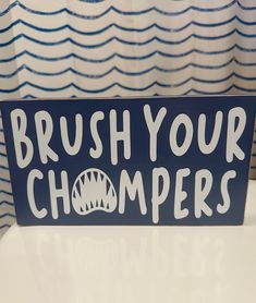 a blue sign that says brush your champagners on it's side, in front of a shower curtain