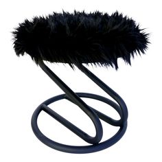 a black metal object with a furry fur on it's top and two circular handles