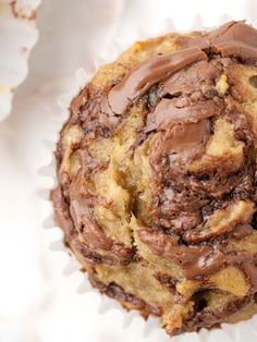 a chocolate chip cookie sitting on top of a white wrapper covered in frosting