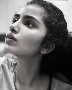 a black and white photo of a woman looking up