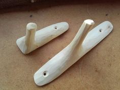 two pieces of white wood sitting on top of a table next to each other with holes in them