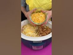 a person in yellow aprons holding a bowl of food