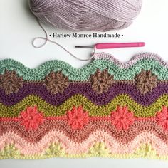 a crochet afghan with yarn and knitting needles