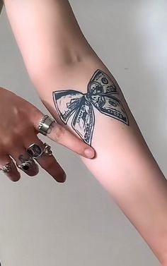 a woman's arm with a butterfly tattoo on it and two rings around her wrist