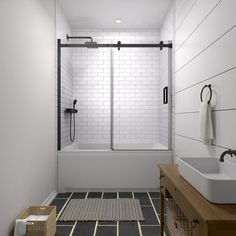 a white bathroom with black and white tile on the floor, sink, shower stall and bathtub