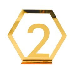 the number two is placed on top of a gold hexagonal object with a white background