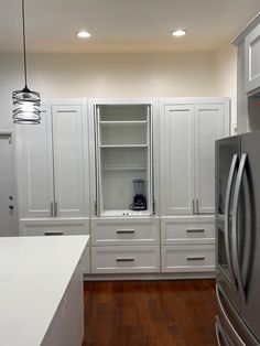 a kitchen with white cabinets and stainless steel appliances