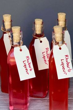 four red bottles with labels on them sitting on a table