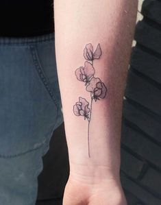 a small flower tattoo on the wrist