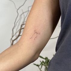 a woman's arm with a small tattoo on the left side of her arm