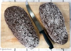 two loaves of bread on a cutting board with a knife