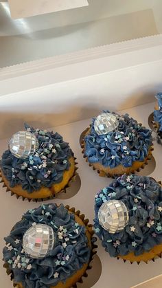 several cupcakes with blue frosting and stars on them are in a box