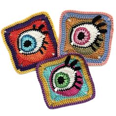 three square crocheted coasters with an eye on the front and one in the middle