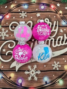 three christmas ornaments are sitting on top of a wooden table with snowflakes and lights