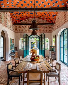 the dining room is decorated with an orange and blue design on the ceiling, along with wooden tables and chairs