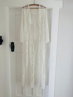 Stunning white vintage robe with ornate detailing and delicate bell sleeves. This piece would be wonderful for a bride or worn as a final touch to a boho-style outfit. Bohemian Long Sleeve Lace Maxi Dress, Bohemian Long Sleeve Maxi Dress For Wedding, Bohemian Long Sleeve Maxi Wedding Dress, Cream Long Maxi Dress For Wedding, White Lace Sleeves Maxi Dress For Wedding, Bohemian Long Sleeve Wedding Maxi Dress, Off-white Long Sleeve Maxi Dress For Wedding, Long Sleeve Maxi Dress With Lace Trim For Wedding, White Bohemian Maxi Dress With Lace Sleeves