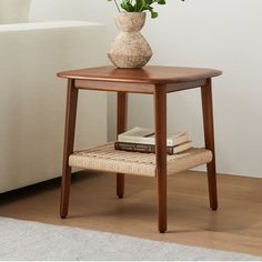 a small table with a flower in a vase and books on the floor next to it