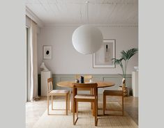 a dining room table with two chairs and a lamp hanging from it's ceiling