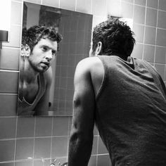 a man is looking at himself in the mirror