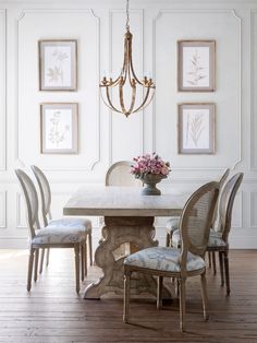 a dining room table with four chairs and a chandelier