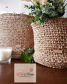 two woven baskets sitting on top of a wooden table next to a glass of milk