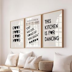 two framed art prints on the wall above a bench in a room with white walls