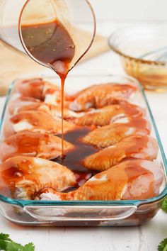 the sauce is being drizzled over the food in the casserole dish